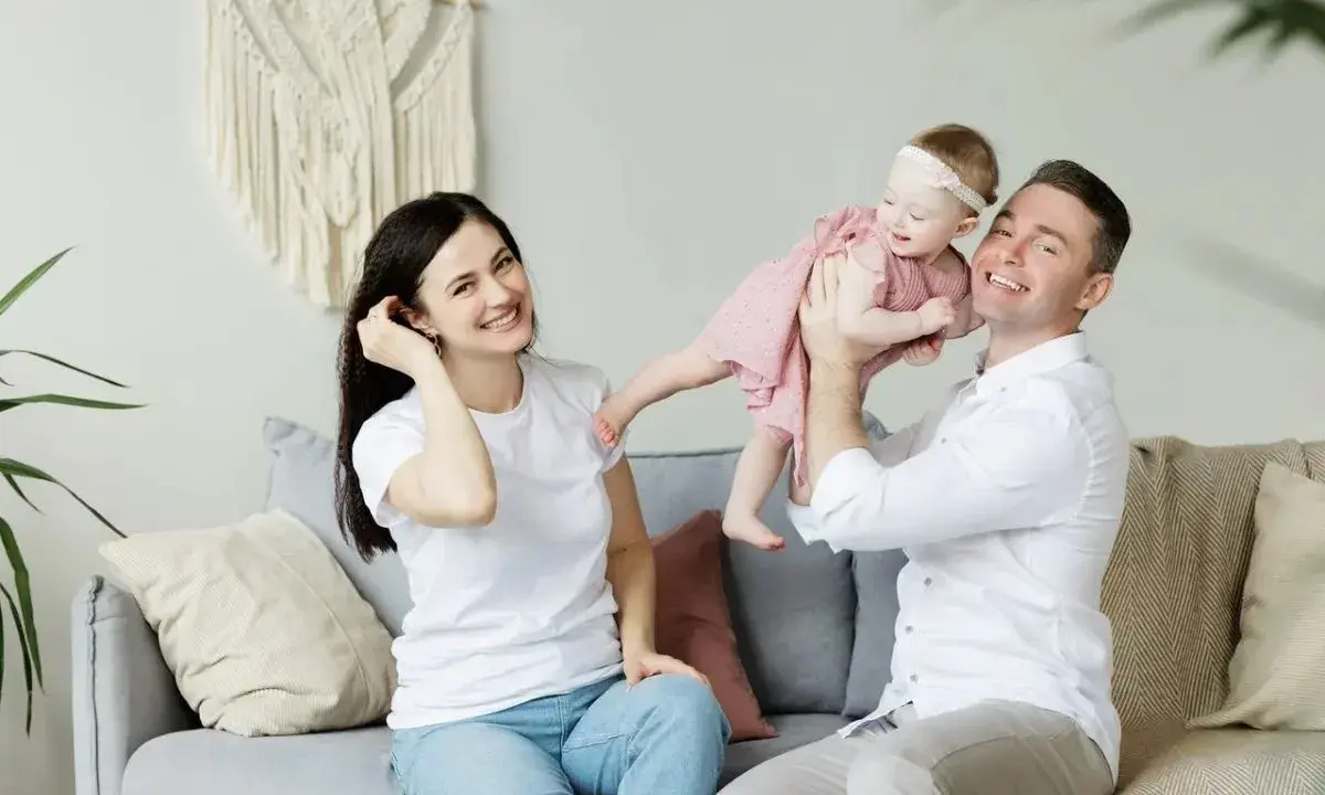 Szczęśliwa rodzinna sesja w Holandii. Tata podrzuca córeczkę, mama uśmiecha się obok.
