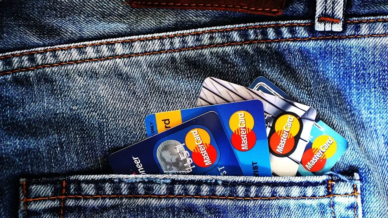 Kilka kart płatniczych, w tym Mastercard, w tylnej kieszeni dżinsów. Czy to preautoryzacja co to?