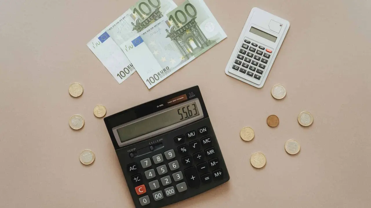 Euro banknoty i monety, dwa kalkulatory. Obliczanie, co można odliczyć od podatku w Niemczech, staje się prostsze.