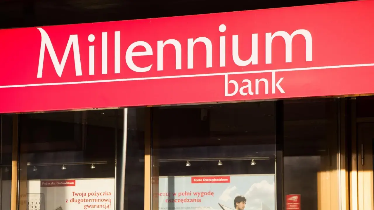 Logo banku Millennium. W pobliżu znajduje się wplatomat, gdzie można wygodnie wpłacić pieniądze.