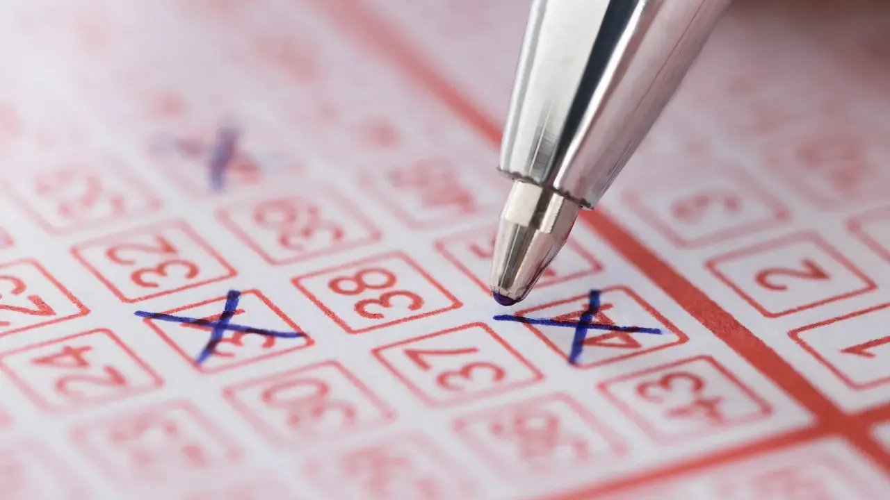 Długopis zaznacza liczby na kuponie lotto. Marzenie o wygranej i świadomość, że czeka nas podatek od wygranej w lotto.