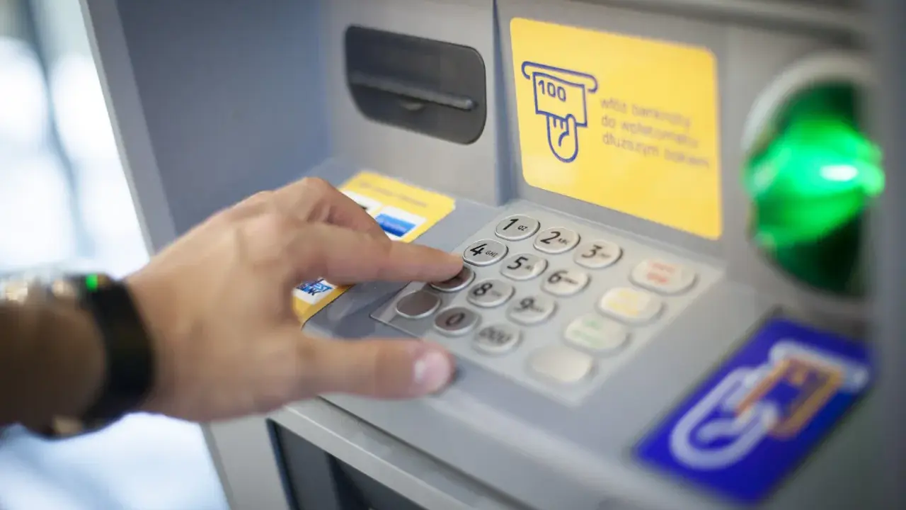 Dłoń wybiera PIN na wpłatomacie bez karty. Wpłata banknotów jest prosta, nawet bez użycia karty.