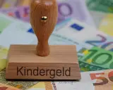 Stempel z napisem "Kindergeld" na tle banknotów euro. Symbol wsparcia dla rodzin, które mogą ubiegać się o świadczenia na dzieci mieszkające w Polsce.
