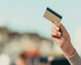 Dłoń trzyma kartę płatniczą, gotowa do transakcji. Dowiedz się, jak płacić kartą za granicą bez obaw.