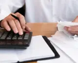 Osoba liczy rachunki, zastanawiając się, zwrot podatku z zagranicy ile lat wstecz można odzyskać.