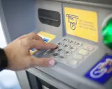 Dłoń wybiera PIN na wpłatomacie bez karty. Wpłata banknotów jest prosta, nawet bez użycia karty.