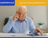 Starszy mężczyzna w okularach, z długopisem przy uchu, korzysta z tabletu. Temat: ochrona przedemerytalna.