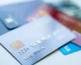 Karty kredytowe leżą na stole. Czy z karty kredytowej można wypłacić pieniądze? Tak, jest to możliwe w bankomatach.