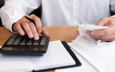 Osoba liczy rachunki, zastanawiając się, zwrot podatku z zagranicy ile lat wstecz można odzyskać.