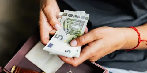 Dłonie liczą euro. Może to oszczędności na emeryturę zagraniczną po mężu, obok zegarka i pamiątek.