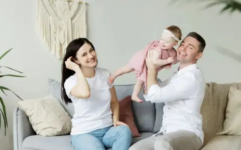 Szczęśliwa rodzinna sesja w Holandii. Tata podrzuca córeczkę, mama uśmiecha się obok.