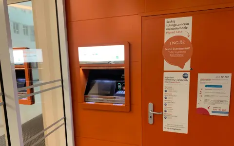 Bankomat Planet Cash z informacją o braku prowizji dla klientów ING. W pobliżu znajduje się też plakat o koronawirusie.