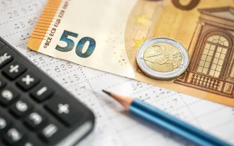 Kalkulator, ołówek i banknot 50 euro na arkuszu z danymi. Obliczanie podatku dochodowego i potencjalnego zwrotu.