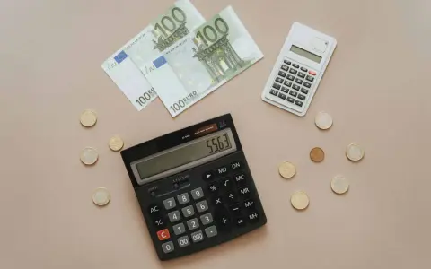 Euro banknoty i monety, dwa kalkulatory. Obliczanie, co można odliczyć od podatku w Niemczech, staje się prostsze.
