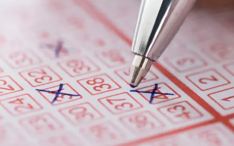 Długopis zaznacza liczby na kuponie lotto. Marzenie o wygranej i świadomość, że czeka nas podatek od wygranej w lotto.