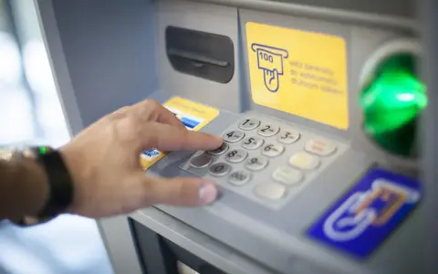 Dłoń wybiera PIN na wpłatomacie bez karty. Wpłata banknotów jest prosta, nawet bez użycia karty.