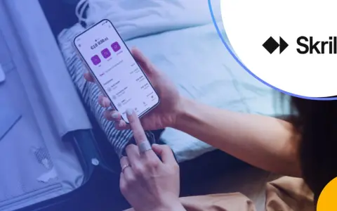 Osoba korzysta z aplikacji Skrill na telefonie, zarządzając finansami. Skrill to platforma płatności online.