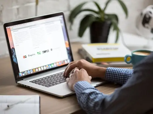 Osoba pracuje na laptopie, szukając informacji o zwrot podatku z Norwegii kiedy. Na biurku kawa i książki.
