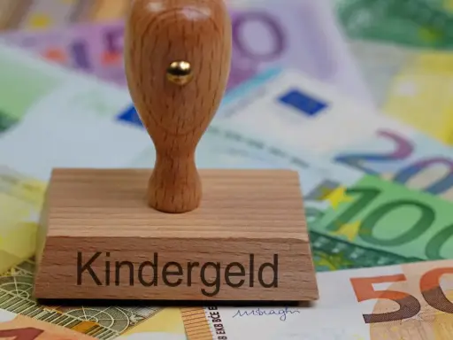 Stempel z napisem "Kindergeld" na tle banknotów euro. Symbol wsparcia dla rodzin, które mogą ubiegać się o świadczenia na dzieci mieszkające w Polsce.