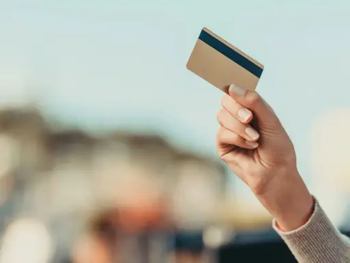 Dłoń trzyma kartę płatniczą, gotowa do transakcji. Dowiedz się, jak płacić kartą za granicą bez obaw.