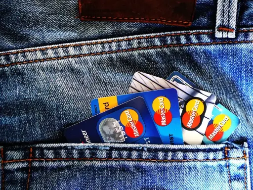 Kilka kart płatniczych, w tym Mastercard, w tylnej kieszeni dżinsów. Czy to preautoryzacja co to?
