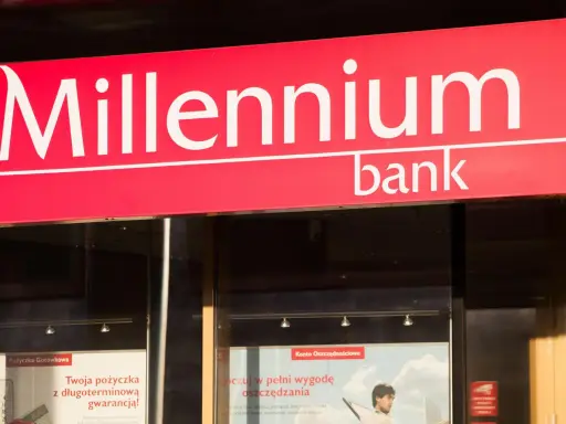 Logo banku Millennium. W pobliżu znajduje się wplatomat, gdzie można wygodnie wpłacić pieniądze.