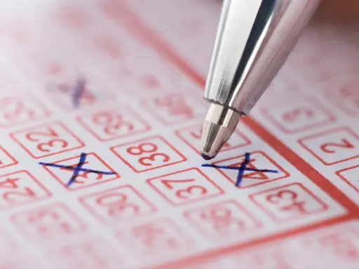 Długopis zaznacza liczby na kuponie lotto. Marzenie o wygranej i świadomość, że czeka nas podatek od wygranej w lotto.