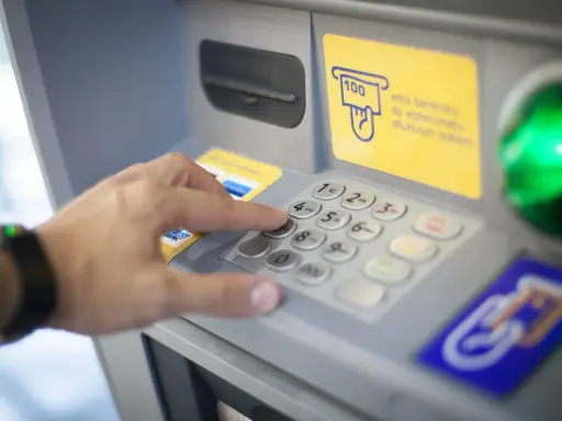 Dłoń wybiera PIN na wpłatomacie bez karty. Wpłata banknotów jest prosta, nawet bez użycia karty.
