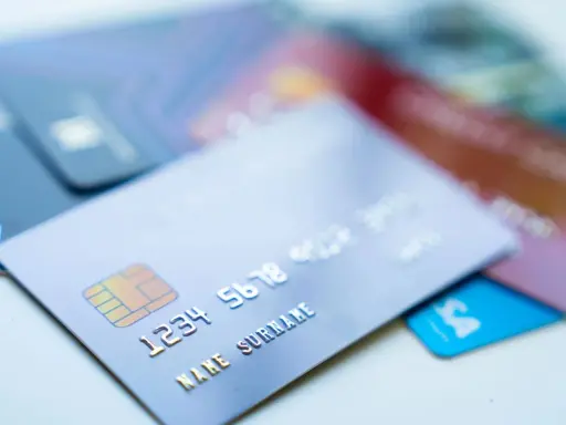Karty kredytowe leżą na stole. Czy z karty kredytowej można wypłacić pieniądze? Tak, jest to możliwe w bankomatach.