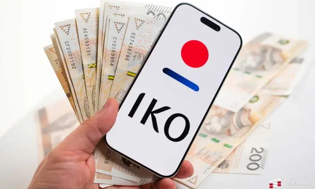 Dłoń trzyma smartfon z logo IKO PKO BP i polskie banknoty. Karta czasowo zablokowana pko? Nie, to tylko gotówka i aplikacja.