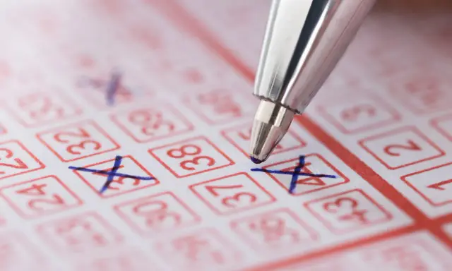 Długopis zaznacza liczby na kuponie lotto. Marzenie o wygranej i świadomość, że czeka nas podatek od wygranej w lotto.