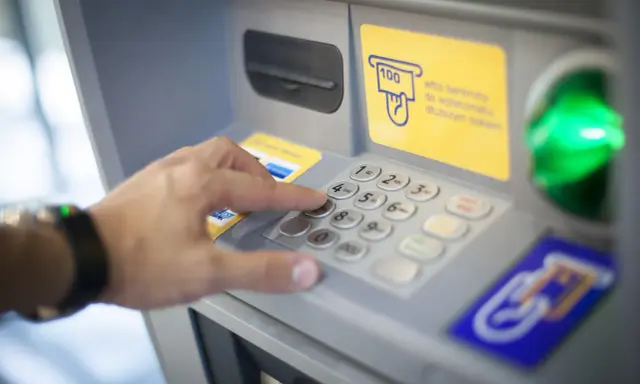 Dłoń wybiera PIN na wpłatomacie bez karty. Wpłata banknotów jest prosta, nawet bez użycia karty.