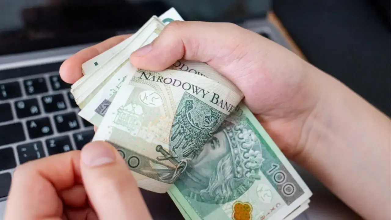 Dłonie trzymają plik polskich banknot&oacute;w 100 zł. Zastanawiasz się, ile można wpłacić na konto bez kontroli?