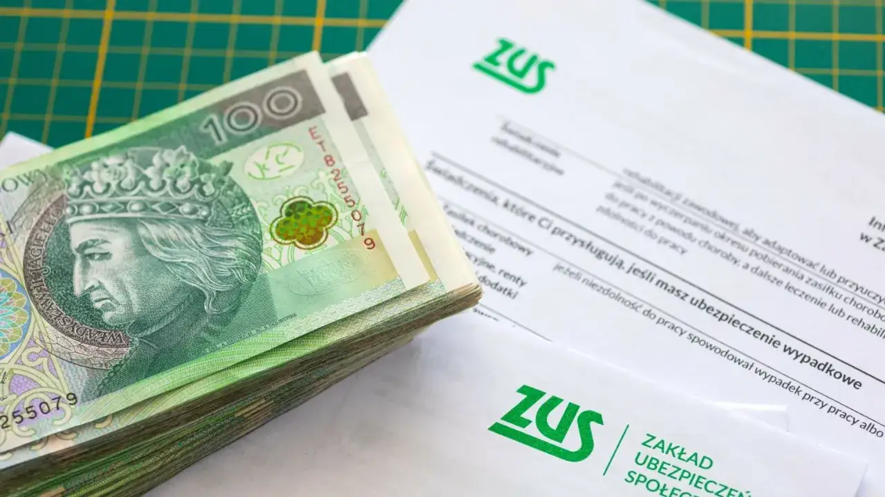 Stos dokumentów ZUS i plik banknotów 100 zł. Może to być dodatek do emerytury lub inne świadczenie.