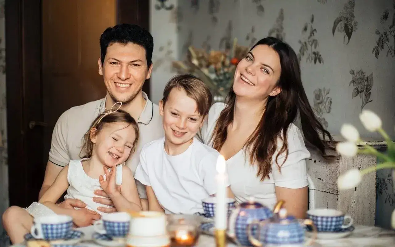 Szczęśliwa rodzina przy stole. Nawet po 18 roku życia, gdy dzieci dorastają, wspólne chwile są bezcenne.