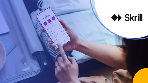 Osoba korzysta z aplikacji Skrill na telefonie, zarządzając finansami. Skrill to platforma płatności online.