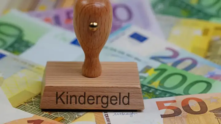 Stempel z napisem "Kindergeld" na tle banknotów euro. Symbol wsparcia dla rodzin, które mogą ubiegać się o świadczenia na dzieci mieszkające w Polsce.